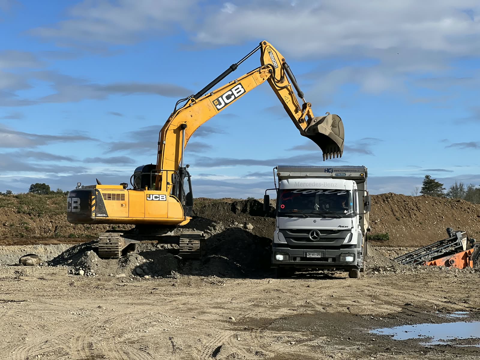 Excavadora cargando camión con áridos