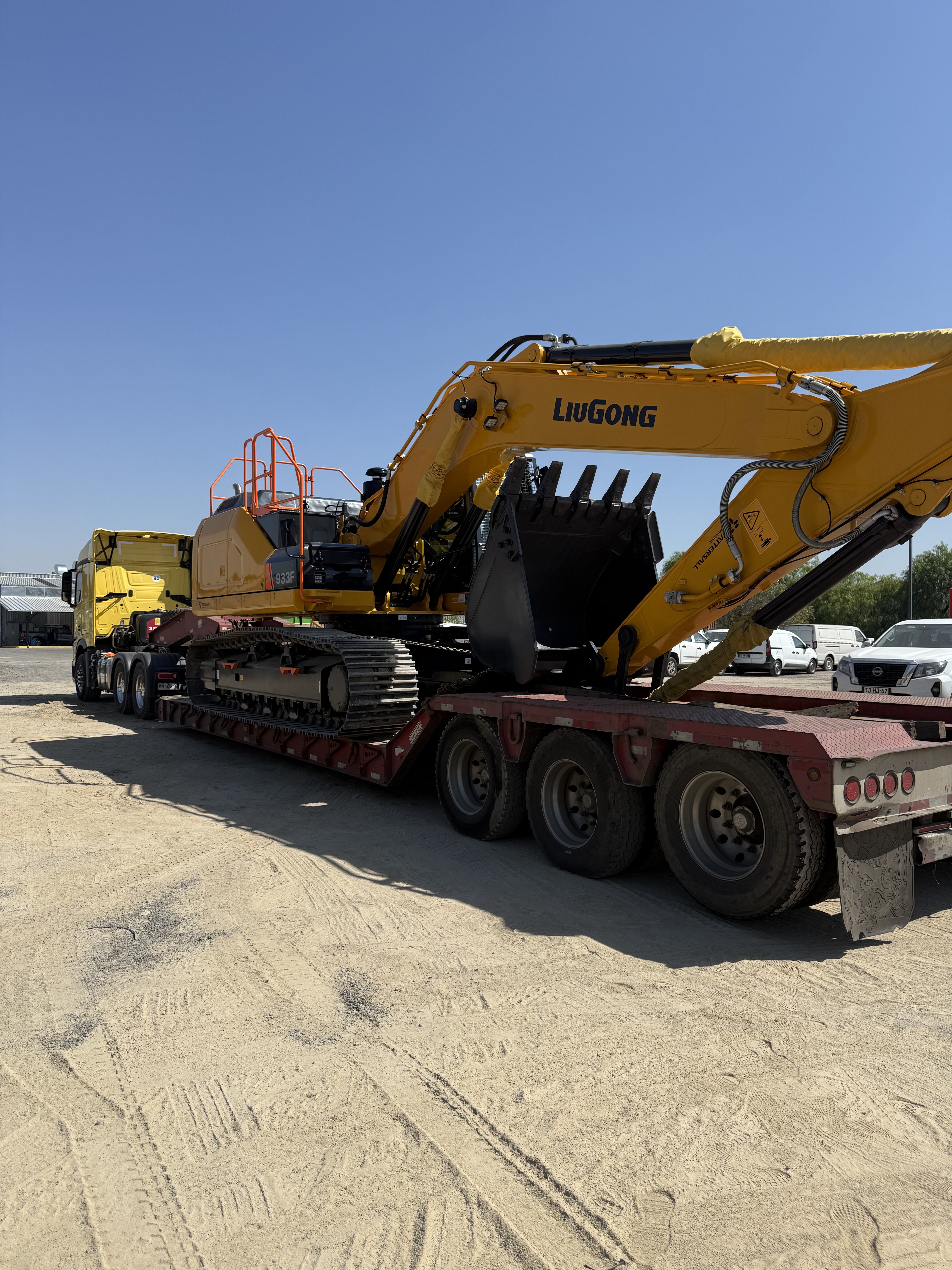 Camión cama baja de Transportes Flores cargado con excavadora